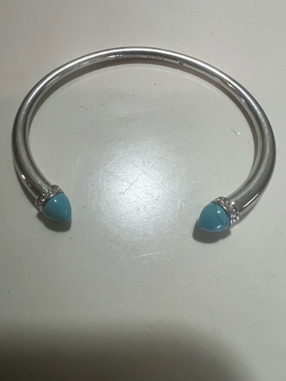 Michael Kors silver tone turquoise hued stone tribal open cuff bracelet.